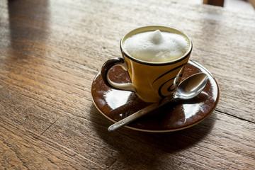 hot cappuchino coffee on wooden table