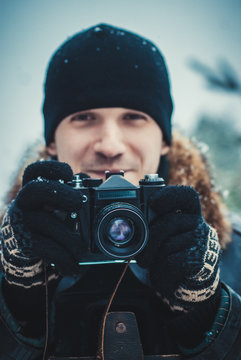 Young man with vintage camera outdoor. concept of winter photography