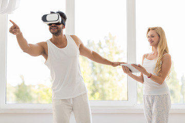 Hispanic Man Wear Virtual Reality Digital Glasses, Happy Smiling Girl Using Tablet Over Big Window