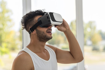 Young Hispanic Man Wear Virtual Reality Digital Glasses, Happy Smiling Guy Over Big Window