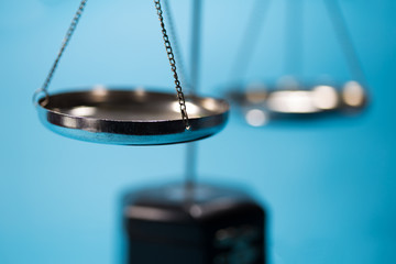 Silver scale of justice on wooden table in blue tone
