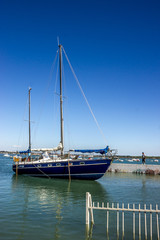 Fototapeta na wymiar Blaues Segelboot im Hafen