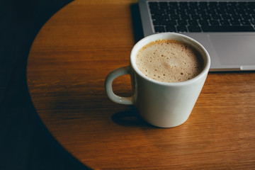 Laptop with cup of fresh coffee