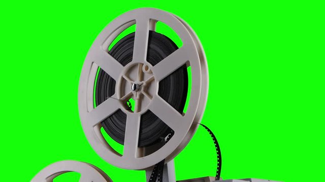 Film is wound onto a cassette projector. Studio green screen