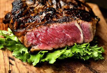 Steak with herbs and beer on a wooden background
