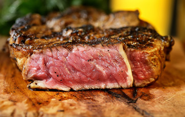 Steak with herbs and beer on a wooden background