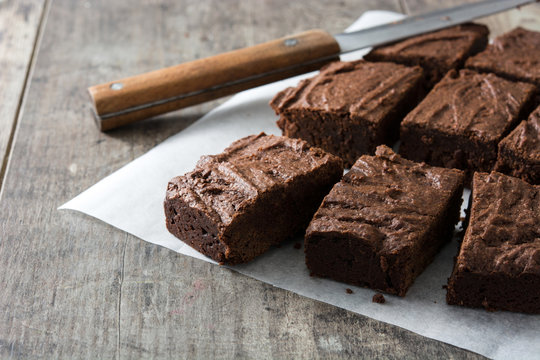 Chocolate brownie portions on wooden background
