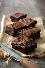 Chocolate brownie portions on wooden background
