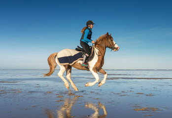 cavalière au galop sur la plage