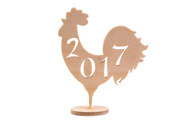 Wooden toy rooster with carved figures. White background. Symbol of the year