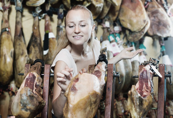 Woman picking delicious prosciutto meat