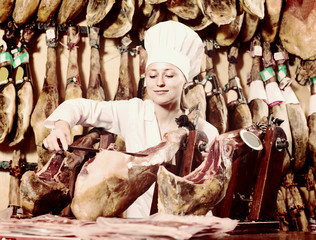 woman cutting dried ham