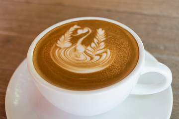 Close up white cup of Coffee, latte with beautiful latte art on the wooden table.