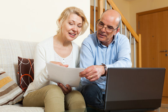 Mature couple with documents and notebook