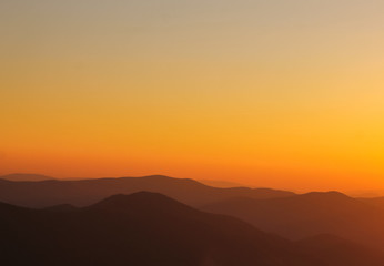 Fototapeta na wymiar minimal mountain shapes on the horizon during sunset