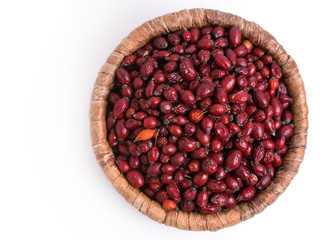 Dried rose hips in wicker basket isolated on white background