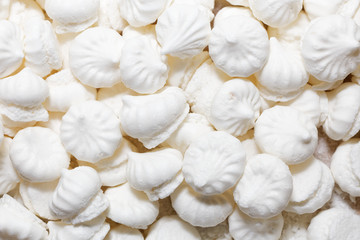 Food background with small white meringue cookies. Top view.