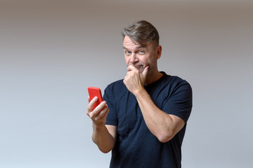 Thoughtful man holding a mobile phone