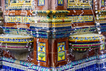 Wassertropfen tanzen vor den bunten Kacheln in einem Brunnen