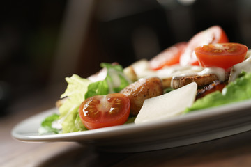 caesar salad with cherry tomatoes on wooden table