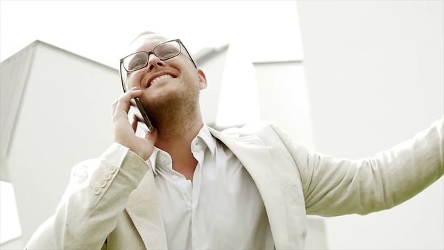 young happy man jumping excited after getting good news on the phone. successful lifestyle background.