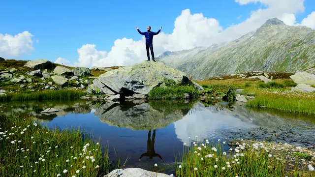 male hiker standing on top of mountain raising hands. successful achievement background.
