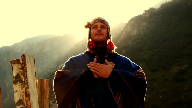 young caucasian man doing spiritual ceremony outdoors. meditation lifestyle. recreational pursuit background.
