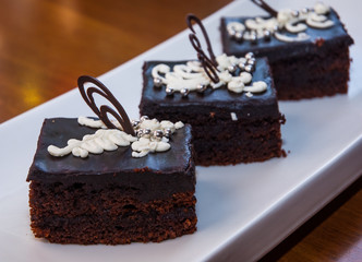 freshly baked brownie-type sponge cake with chocolate on wood table