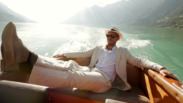 happy handsome single man in casual clothes enjoying life on boat deck riding over lake. carefree happiness lifestyle background.