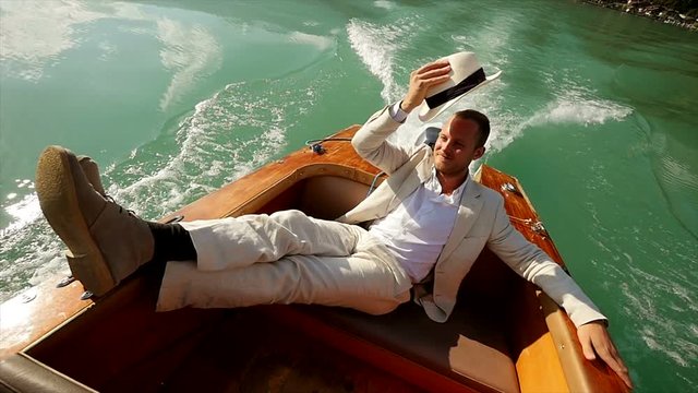 young caucasian man relaxing on boat deck wearing white casual suit. happiness lifestyle background.