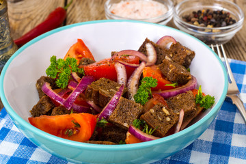 Simple salad with bread, tomato, red onion, vegetable oi