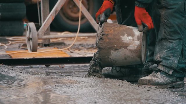 Pouring, Laying Concrete at the Construction Site using Buckets of Cement. Slow Motion