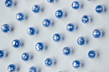 blue glass beads polyhedron shape pattern closeup on a white background