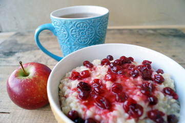 Healthy breakfast, vegetarian. Oatmeal with cranberries, apple, tea.