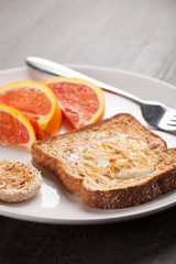 Toad in a hole egg breakfast with Cara Cara oranges angled view