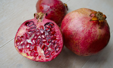 Photo of open pomegranate on wooden background