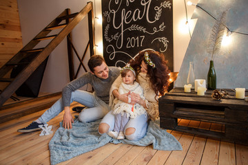 Obraz na płótnie Canvas New year and christmas portrait of happy family in knitted sweaters on loft background with caligraphy new year 2017. Happy new year concept