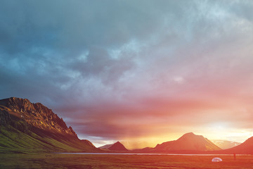 Fototapeta premium Travel to Iceland. Beautiful Icelandic landscape with mountains, sky and clouds. Trekking in national park Landmannalaugar. Rainy Evening in Camping near Alftavatn lake.