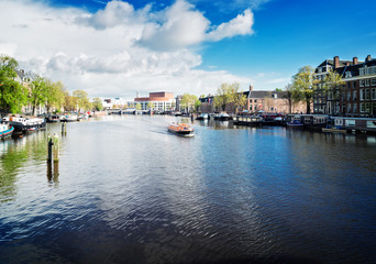 embankments of Amstel canal with traditional houses in Amsterdam, Netherlands, retro toned