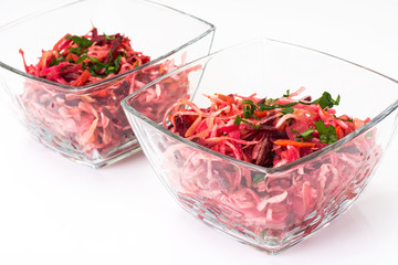 Vegetable salad in a glass salad bowl on a white background