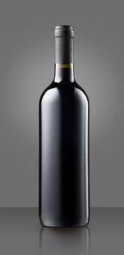 Blank full capped red wine bottle on grey