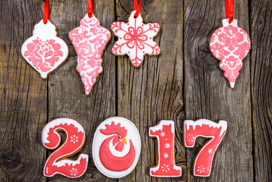 Gingerbread cookies hanging over wooden background