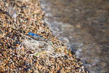 Environmental polluted seaside with plastic, on a pebble beach