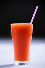 cold Papaya smoothie in a glass with a straw  