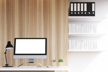 Close up of blank computer monitor and bookshelves