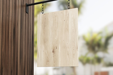 Signpost hanging on chain on wooden wall