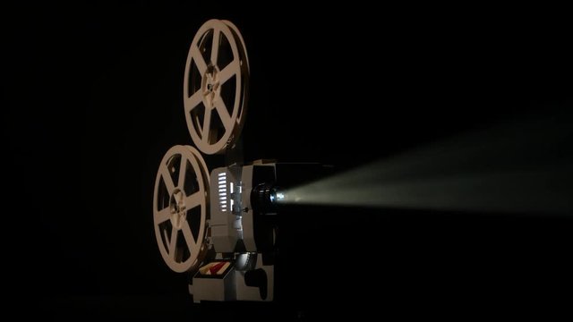 Shows movie in a projector. Black background