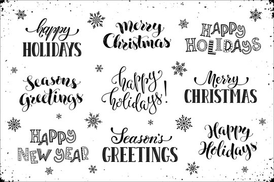 Hand Written New Year Phrases. Greeting Card Text  With Snowflakes Isolated On White Background. Happy Holidays Lettering In Modern Calligraphy Style. Merry Christmas And Season's Greetings Lettering.