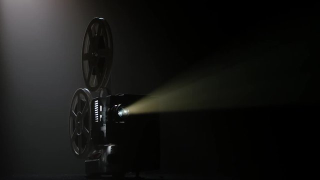 Dark movie theater. Projector illuminated by lights broadcasts a movies