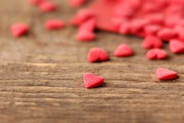 Small candy hearts on wooden table